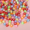 A pile of colorful round acrylic alphabet beads in various shades including red, green, yellow, and purple.