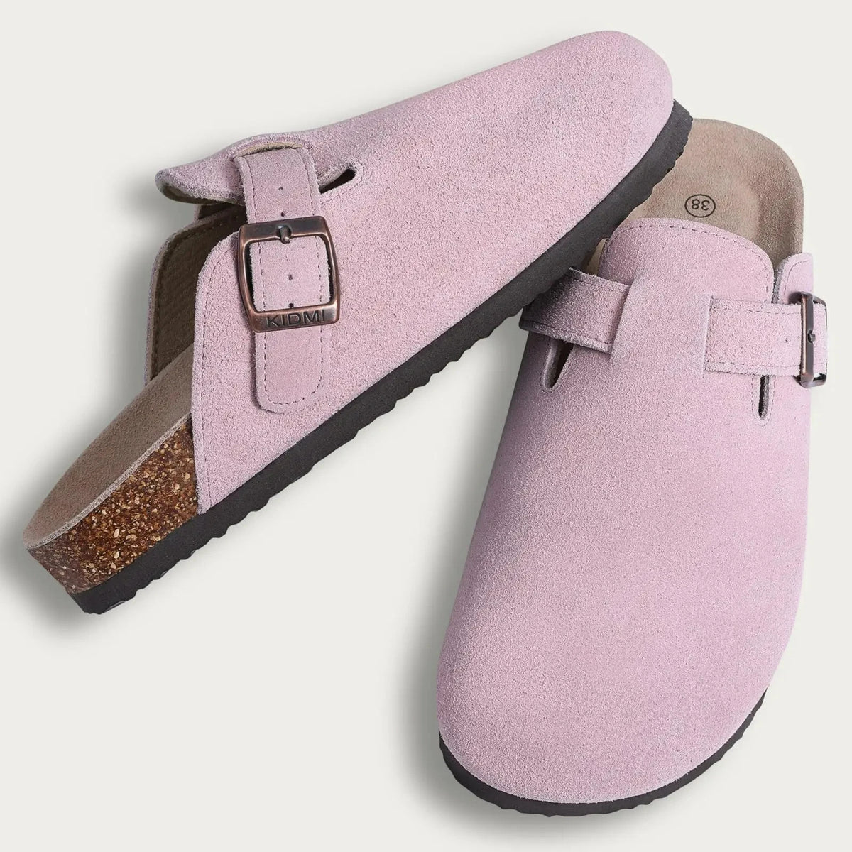 Pink suede cork mules with a leather strap and arch support visible from the side.