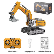 A yellow mini remote control excavator with a hydraulic arm, charging cable, and instruction manual.