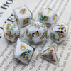 A set of milk white resin dice featuring gold accents and a black kitten design.