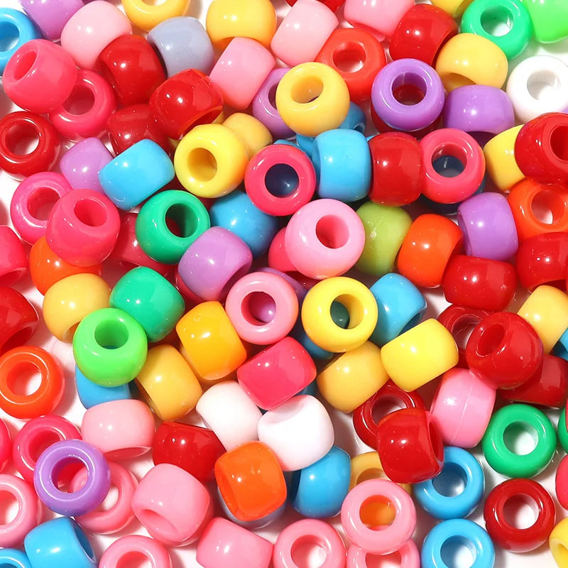 A collection of colorful rainbow pony beads in various shades including pink, yellow, green, and red.