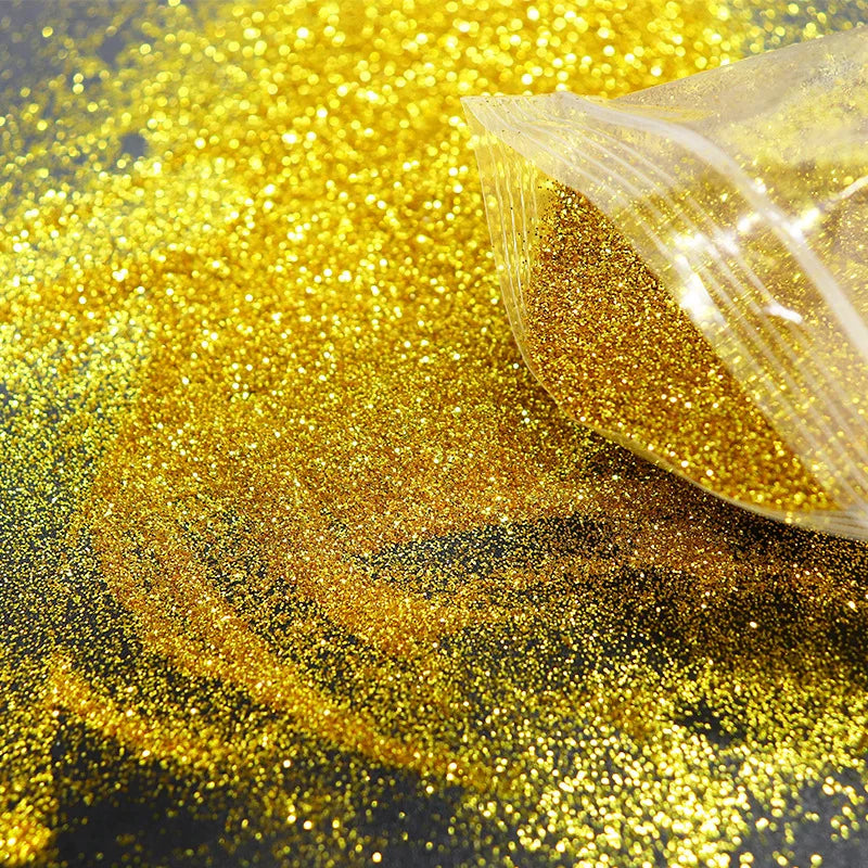 A pile of holographic gold glitter powder scattered across a dark surface.