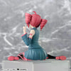 A PVC figure of Hatsune Miku with pink hair styled in twin buns, wearing a teal outfit, sitting pose.