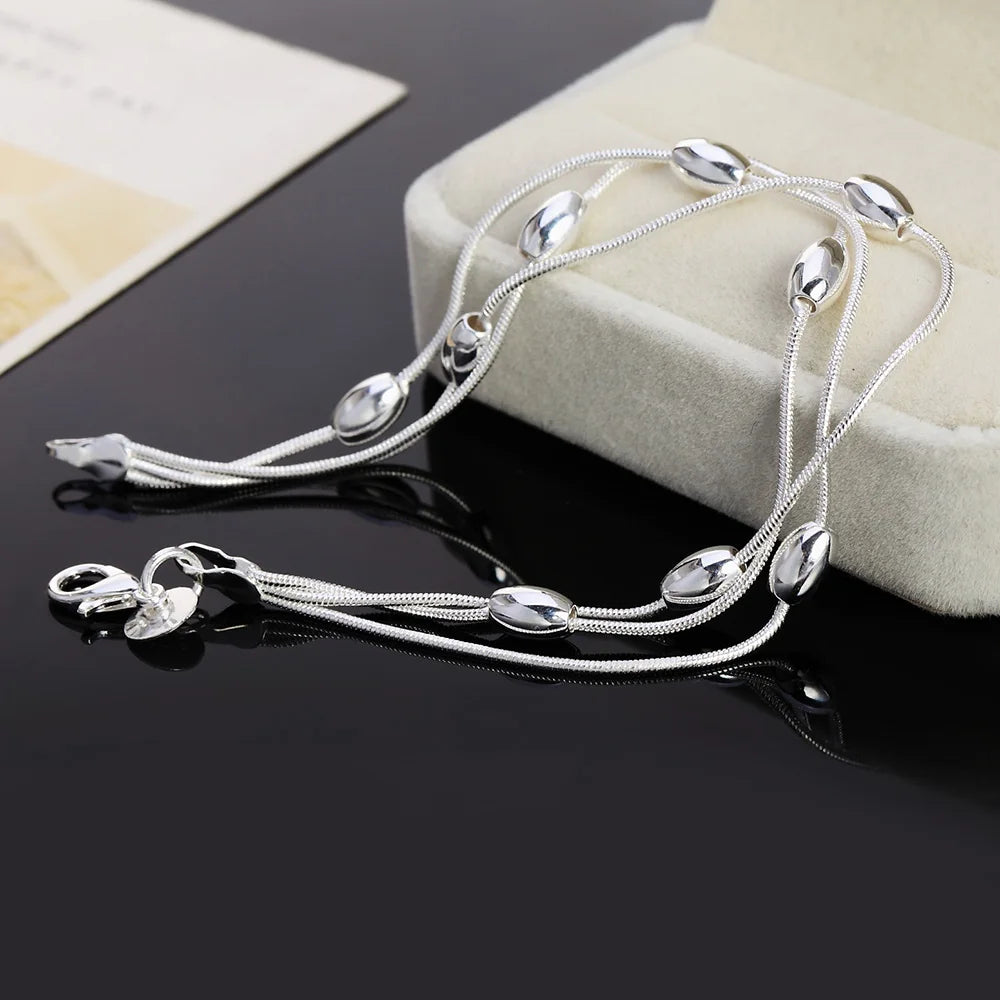 Elegant sterling silver snake chain bracelet for women displayed on a white box.