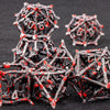 A pile of black metal dice shaped like dragons, some with red accents, resting on a dark surface.