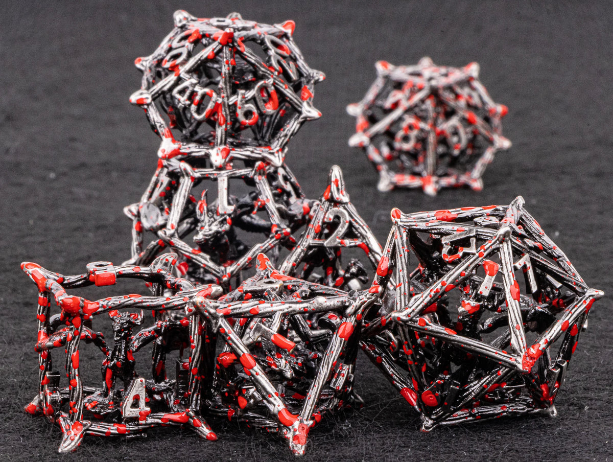 A pile of black metal dice shaped like dragons, some with red accents, resting on a dark surface.