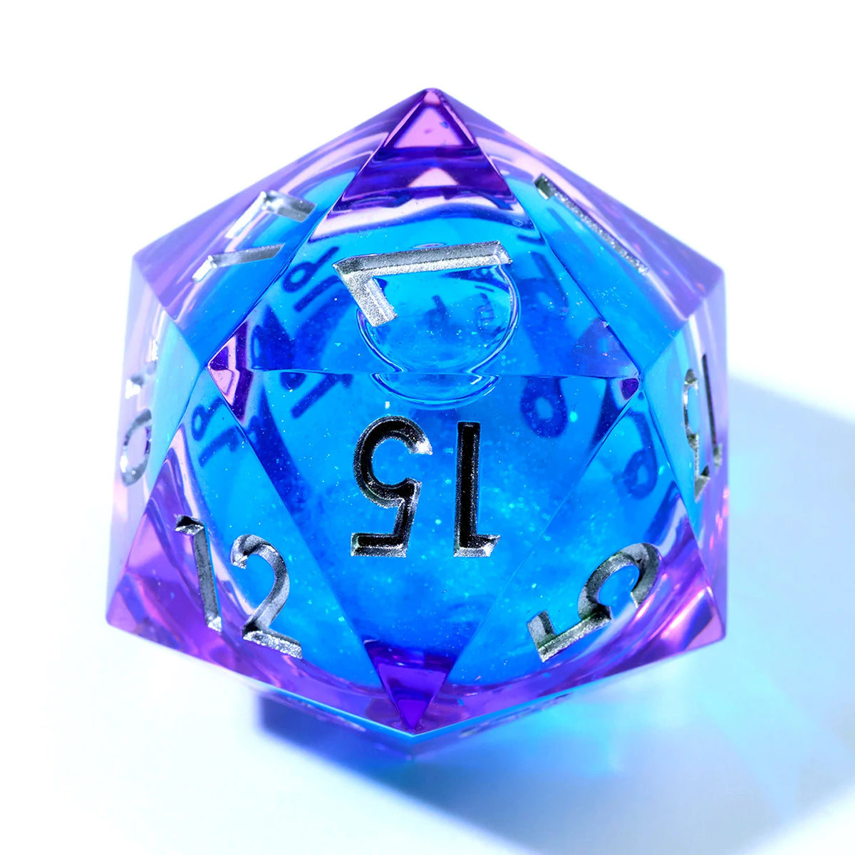 A handmade resin D20 die with a large blue and purple liquid swirl, viewed from above.