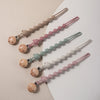A set of silicone pacifier clips featuring bear paw shapes in various pastel colors like pink, green, and beige.
