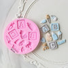 A pink silicone cake molds set featuring various baby-themed shapes like letters, bottles, and pacifiers.