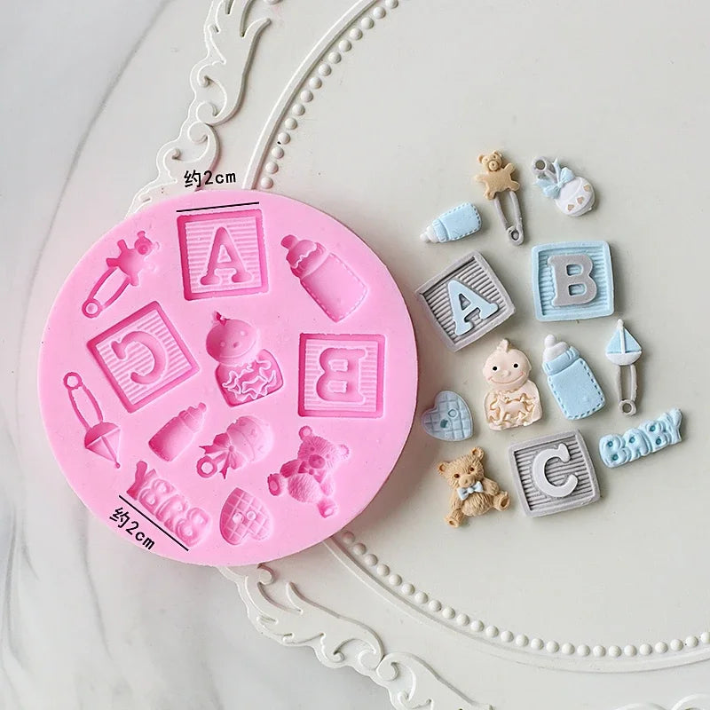 A pink silicone cake molds set featuring various baby-themed shapes like letters, bottles, and pacifiers.