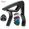 A black guitar capo set including 7 pieces, such as a capo and picks, shown in a close-up view.