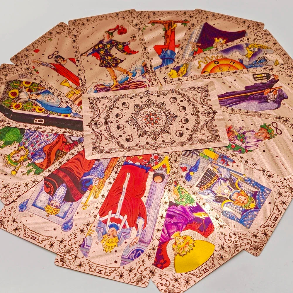 A spread of gold foil tarot cards with a rose pink oracle finish showing various mystical imagery.