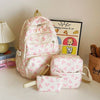 Un ensemble de sacs à dos et d'une pochette à imprimé de nœuds rose et blanc, présentés sur une surface claire.