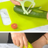 Hands are preparing food on a bright green cutting board using a kids cooking set with safe knives and tools.