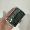 A roll of dark green velvet faux suede braided ribbon for crafting and gift wrapping is held in a hand.