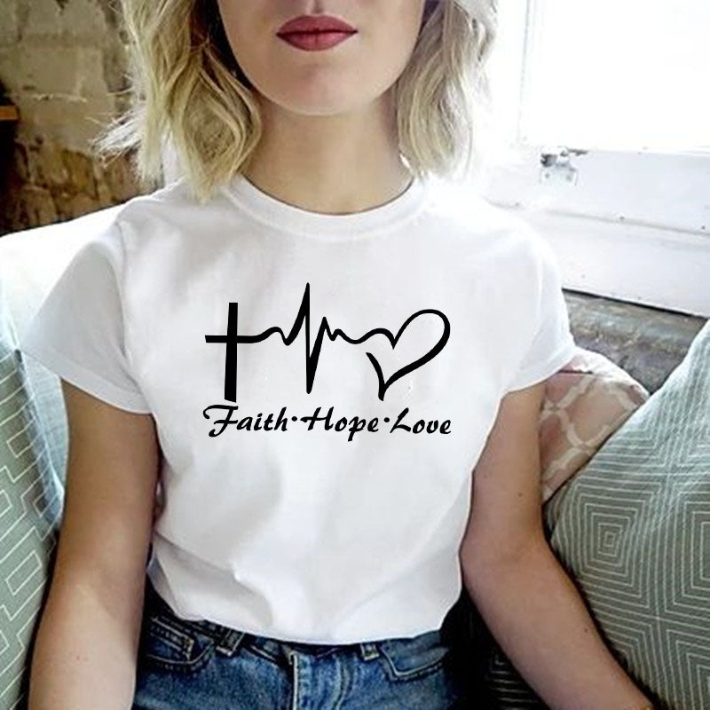 A woman wearing a white t-shirt with the words Faith Hope Love printed on it.