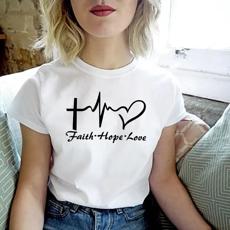 A woman wearing a white t-shirt with the text Faith Hope Love printed on it.
