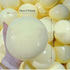 يد تمسك بكرة مضغ (squishy) كبيرة ناعمة صفراء شاحبة للاسترخاء، مع مؤشر قياس.