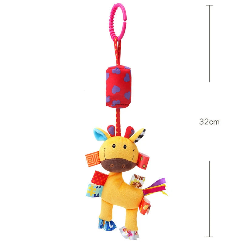 A yellow plush animal toy with red accents hanging from a pink loop, used as a rattle for infants.
