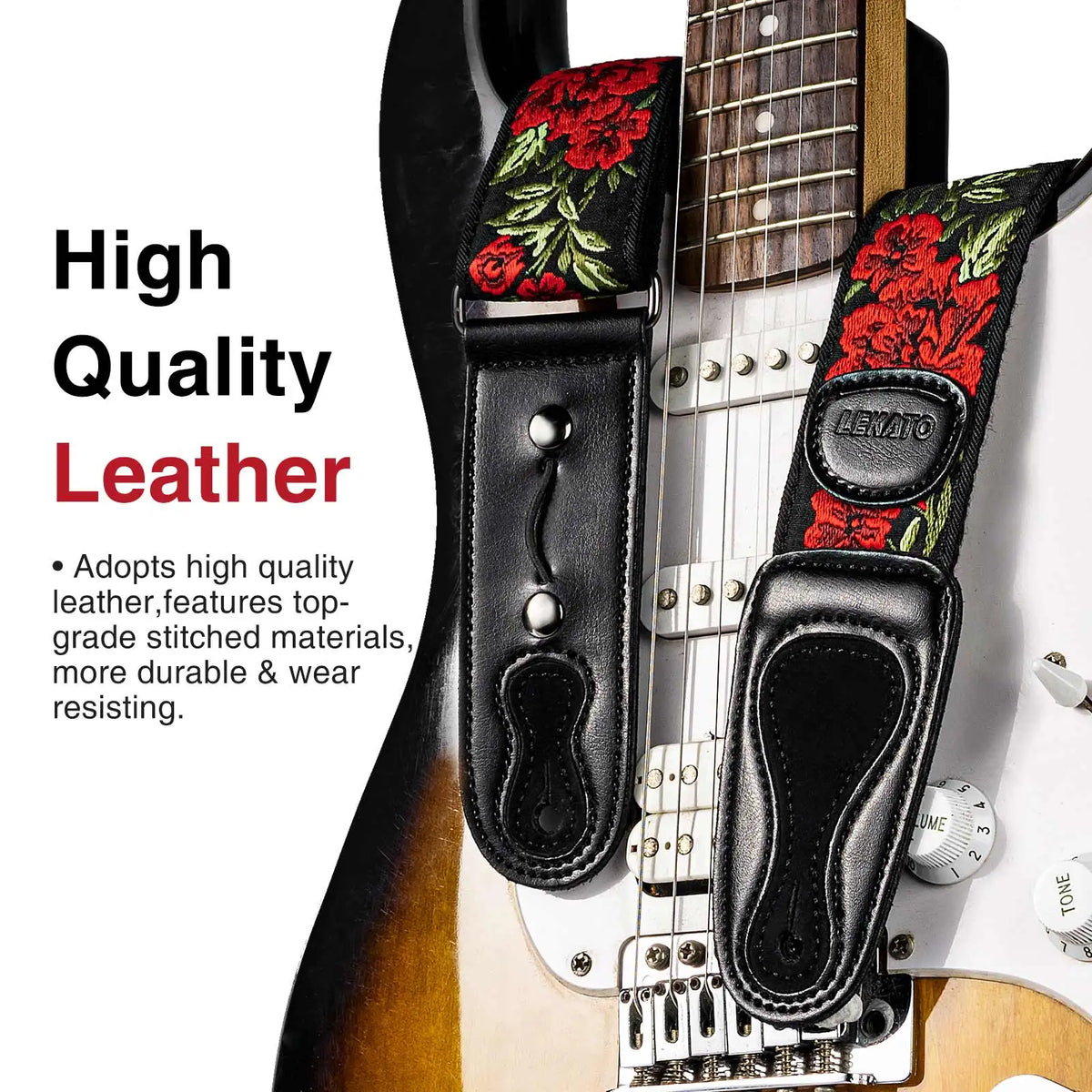 A close-up of a black leather guitar strap featuring red floral embroidery and pick holders on a vintage electric guitar neck