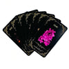 A stack of black oracle cards featuring a lilac design and gold accents.