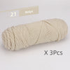 A skein of beige soft cotton blend yarn for knitting and crochet, shown in a tight coil.