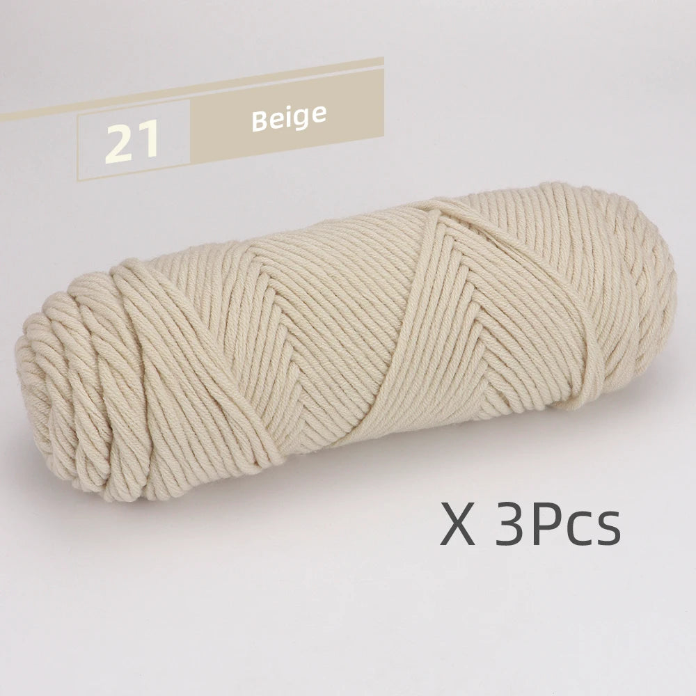 A skein of beige soft cotton blend yarn for knitting and crochet, shown in a tight coil.