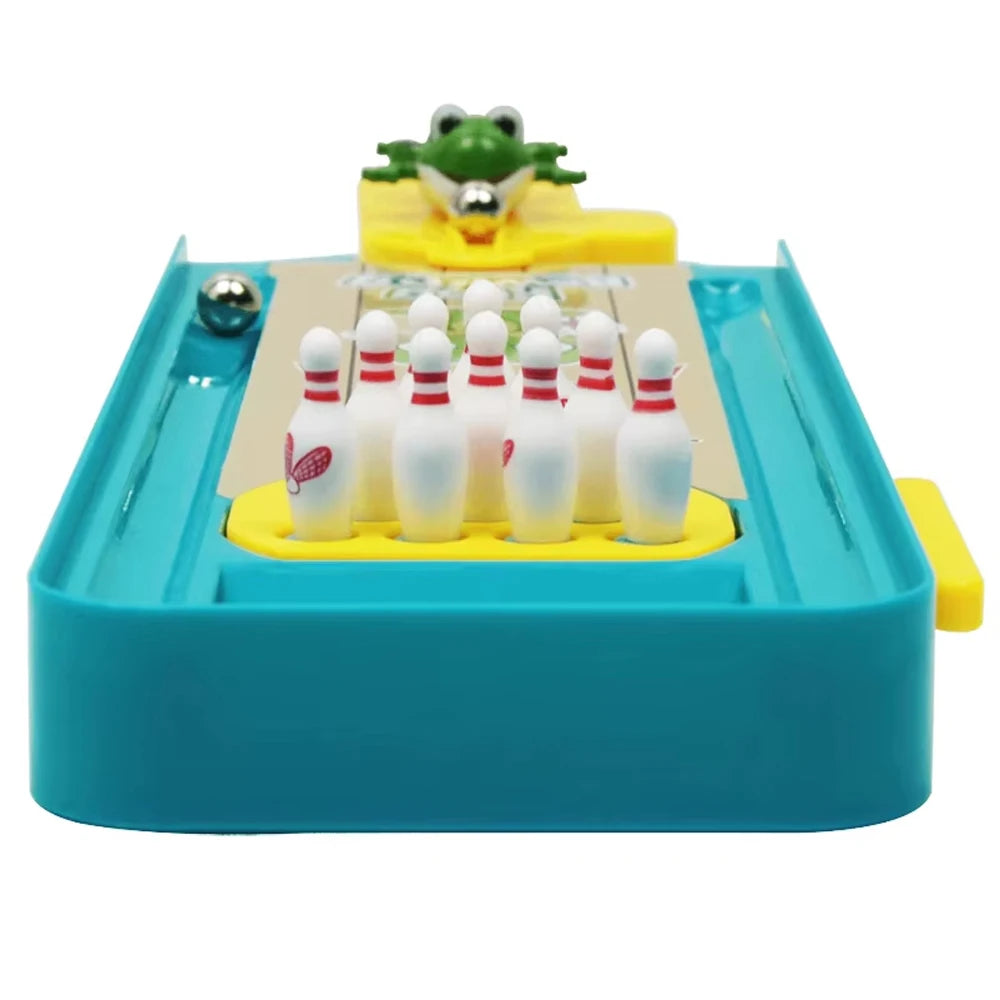 A mini frog bowling game set featuring a yellow lane, white and red bowling pins, and a green frog topper.