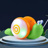 An orange and white musical pull-along snail toy is featured against a dark background.