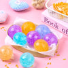 A collection of six colorful, translucent, soft squeeze balls in purple, yellow, and blue resting on pink surfaces.