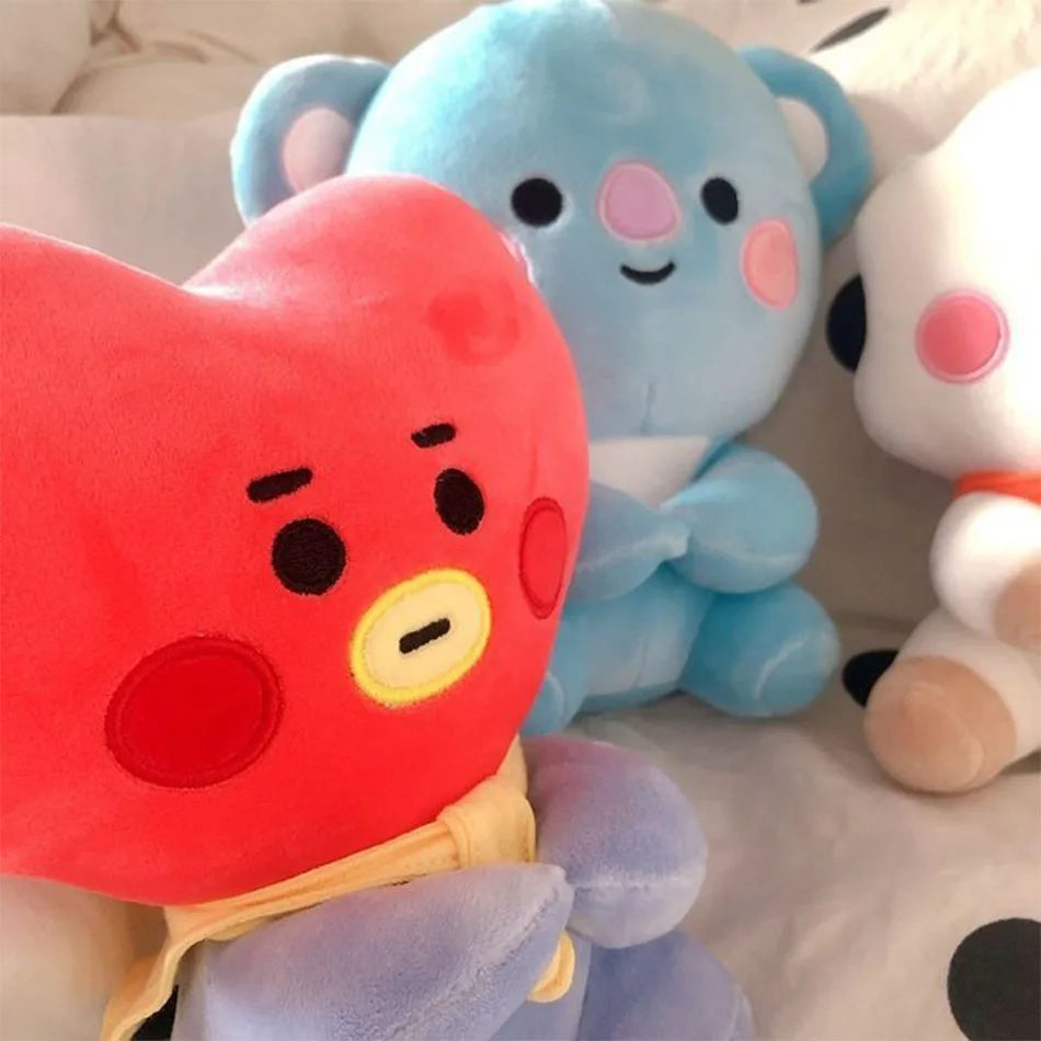 A close-up of three soft plush toys in red, blue, and white colors.