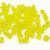 A pile of faceted yellow bicone crystal glass beads for jewelry making.