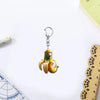 Acrylic keychain featuring a green monkey design with a yellow banana, set against a white background.
