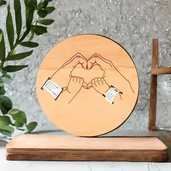 A wooden heart design keepsake with wristbands displayed on a wooden stand.