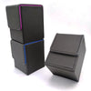 A stack of dark gray leather deck boxes, some with purple and blue accents, are displayed on a white surface.