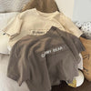 A gray short-sleeve t-shirt with the text GUMMY BEAR printed on the chest, displayed on a light surface.