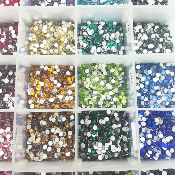 Et rutenett med små glasskrystall rhinestones i gull, grønt, blått og sølv.