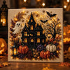 A decorative mosaic art piece featuring a black house, glowing pumpkins, and autumn foliage with sparkling lights.
