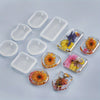 A collection of silicone keychain molds in various shapes and floral designs for DIY epoxy resin jewelry.