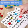 A hand points to a bingo card with numbers, colored bingo chips, and disposable bingo paper sheets.