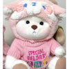 A pink and white fluffy teddy bear plush with a pink sweater featuring a special delivery design.