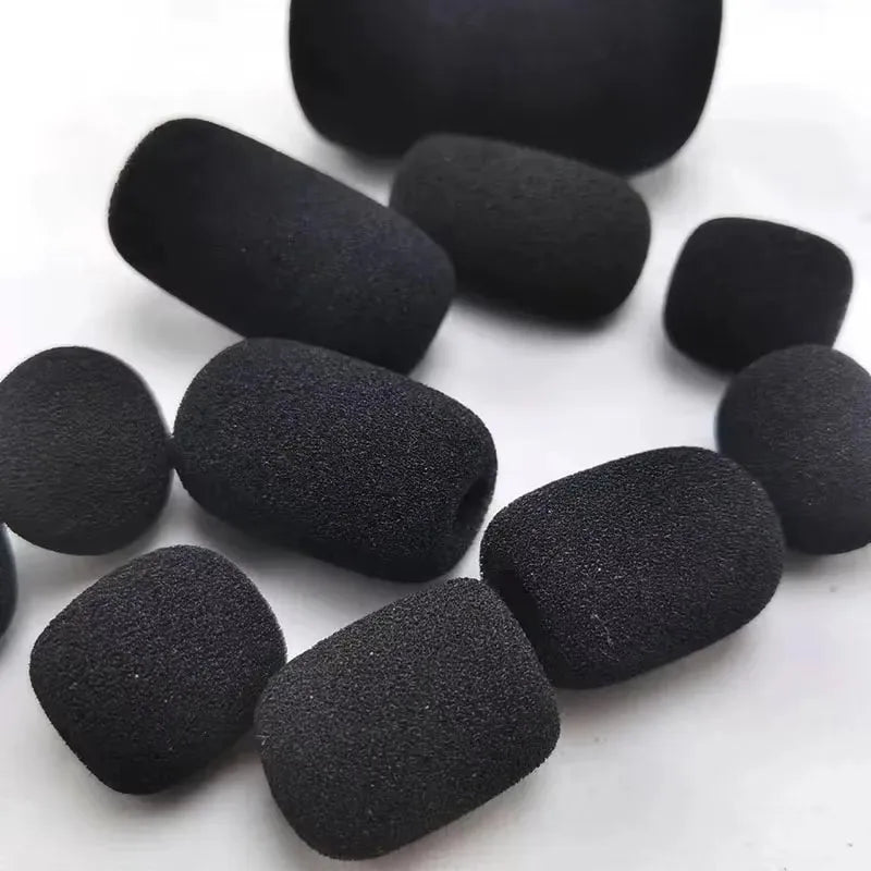 A collection of ten black foam covers for replacement microphone heads arranged in a circle.