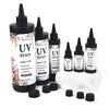 A collection of black UV resin glue bottles with dropper tips and white resin on a white rock.