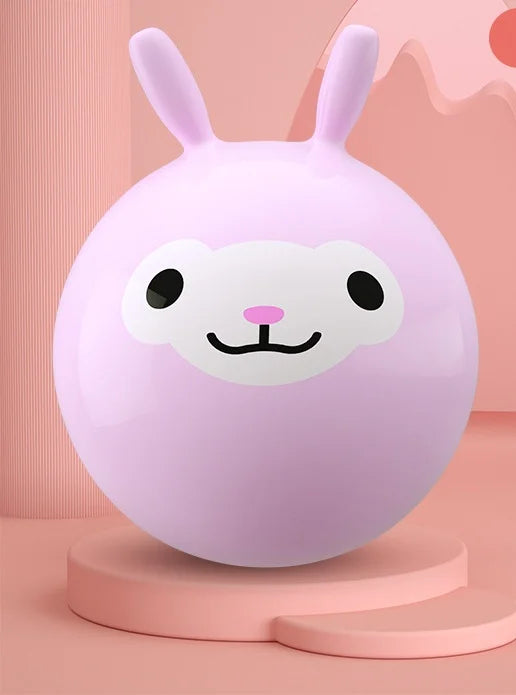 A pink inflatable hopper ball with a white face design is displayed on a light pink stand.