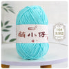 A ball of bright turquoise chenille yarn labeled with Chinese characters for knitting and crochet.