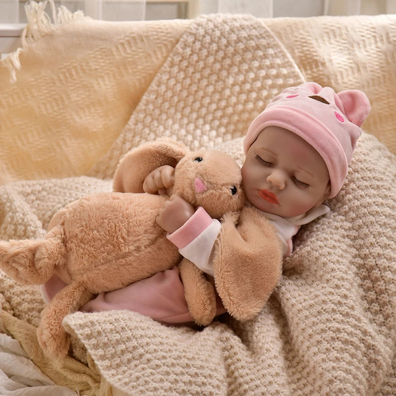 A realistic baby doll wearing a pink knitted hat and a pink romper, cuddling a fluffy brown stuffed animal.