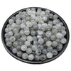 A pile of clear and gray acrylic round beads for jewelry making in a black bowl.