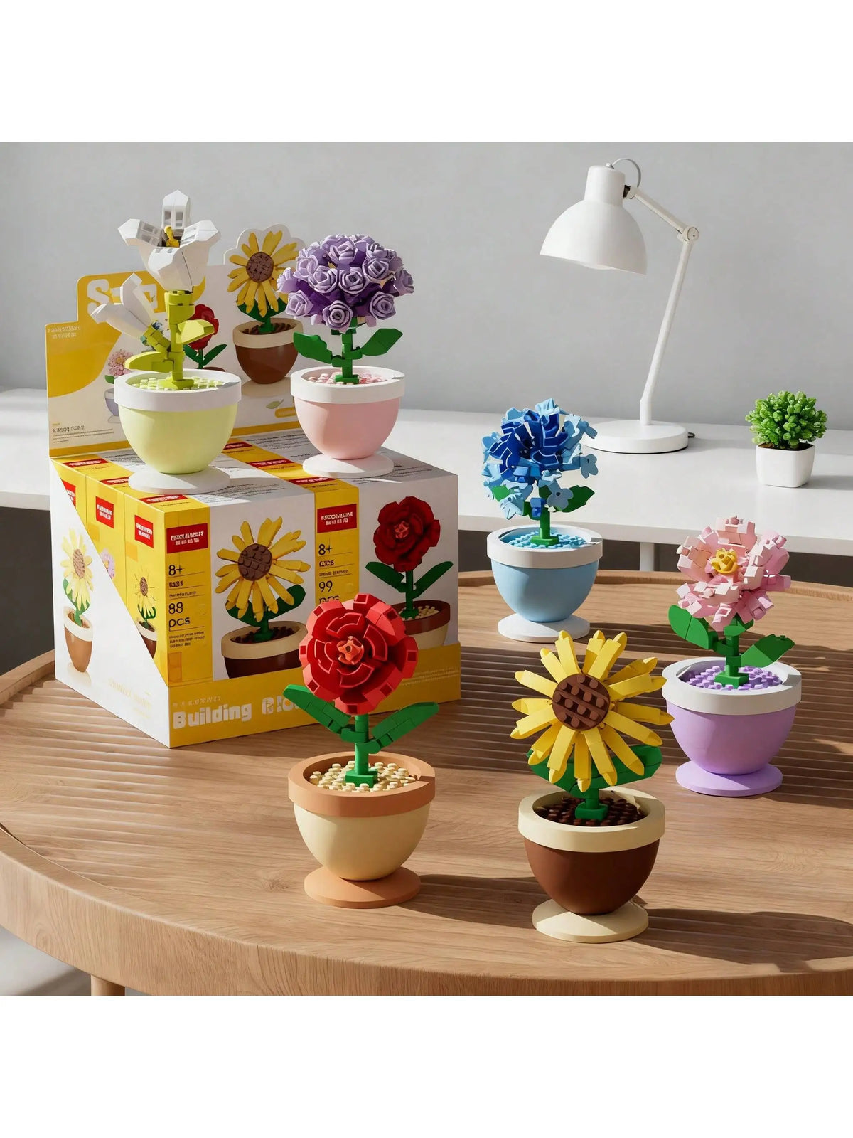 A set of colorful building block flowers in various pots and a white desk lamp on a wooden table.