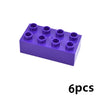 Un bloc plastique violet avec six indentations circulaires pour construire, montrant six pièces.