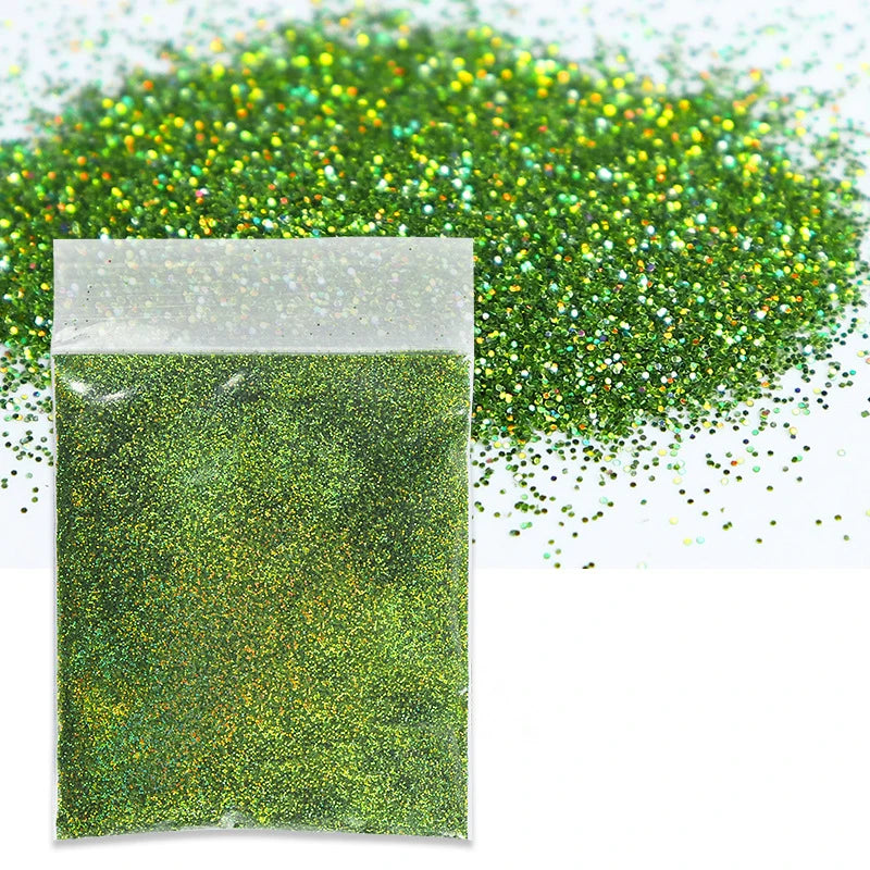 A small plastic bag filled with holographic green glitter powder next to a pile of loose green glitter.
